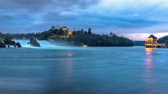 The evening atmosphere at the Rhine Falls. A view of the two castles, Schloss Laufen Wörth Castle.