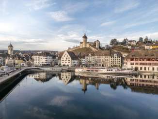 View from the clear Rhine to the wintry Old Town with ship and Munot.
