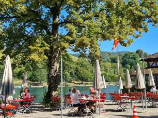 Terrace Restaurant Unterhof Red tables and chairs and white parasols stand on a terrace directly on the Rhine.