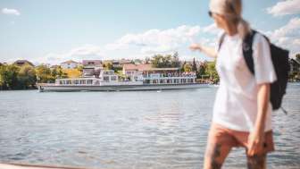 regular boat service on the Rhine A woman points to the regular boat service passing by on the Rhine.