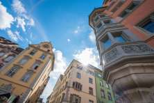 Houses on the Fronwagplatz Schaffhausen in yellow, ochre and green. View of the Fronwag tower with Fronwag clock and oriel windows