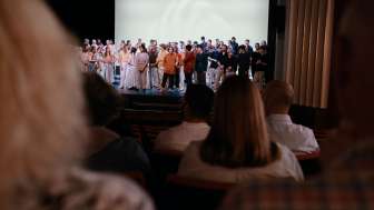 Municipal theatre Schaffhausen Performance with audience A theater stage with many artists. Spectators sit on the red seats in the auditorium.