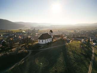 Wilchingen village A church stands on a hill with vines. Behind it you can see the village.