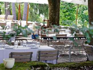 Garden restaurant Bad OSterfingen Tables covered in white with wooden chairs stand in a garden restaurant under chestnut trees.