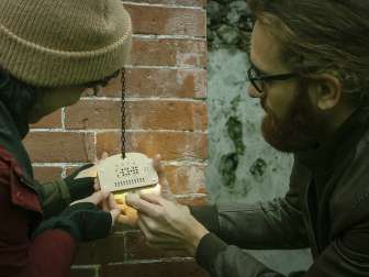 Sato Code Two people try to pick a special lock outside in an escape room.