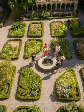 A group stands around a small fountain in the Schaffhausen herb garden. A woman tells more about the story.