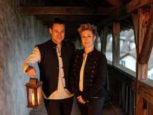 A woman and a man on a fortress. The man holds a lantern.