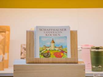Das Kochbuch mit Rindheftung hat eine Zeichnung des Munots mit zwei lustigen Hühnern auf dem Deckblatt.