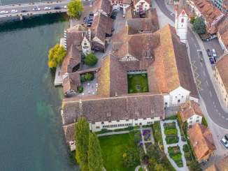 A bird's-eye view of St. Georgen Abbey, located directly on the Rhine in Stein am Rhein. You can see the church with its steeple, the cloister with its inner courtyard, and the garden.