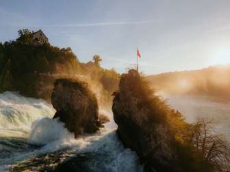 View from behind of the two rocks in the middle of the waterfall. Goldie's light shines on the waterfall.