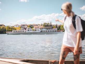 A woman points to the regular boat service passing by on the Rhine.