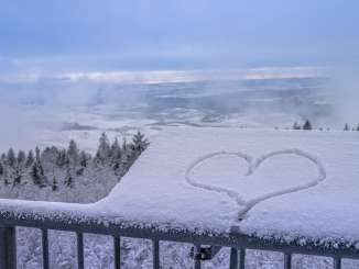 View of Hagenturm with snow View of a snow-covered landscape from the viewing platform of the Hagenturm. There is snow on a panel and a heart is drawn in it.