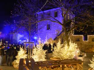 Winter magic Schloss Laufen Rhine Falls A castle and fir trees illuminated with lights.