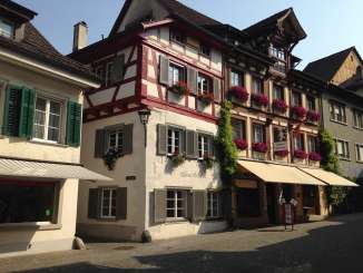 Exterior view of a timber-framed house in the old town of Stein. The windows are decorated with shutters and flowers.