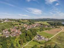 Aerial view of a village surrounded by greenery. You can still see the Rhine at the edge.