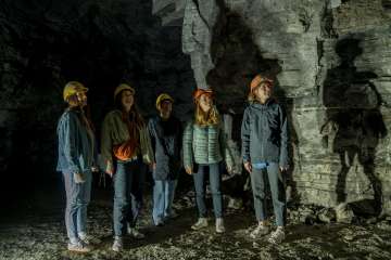 Schleitheim gypsum gallery Five friends are wearing yellow and orange helmets. They are standing in a former plaster gallery.