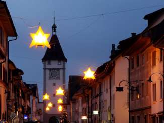 Advent market Neunkrich Shining stars hang over an alley in Neunkirch. A tower can be seen in the background.