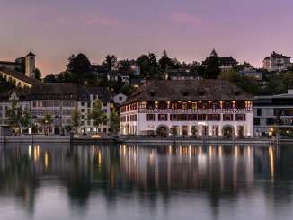 A view of the Rhine, the Munot, and the Güterhof Schaffhausen at dusk.