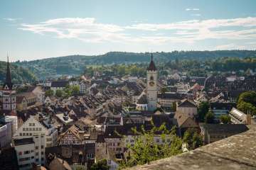 View over the rooftops of Schaffhausen's old town. A church tower rises up in the center.