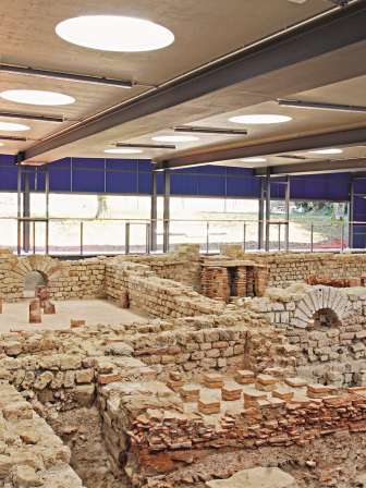 The remains of a former Roman thermal bath can be viewed in a large hall as a museum.