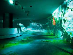 Rhyality Rhienfall Program A room with various projectors. Water images are projected onto the walls.