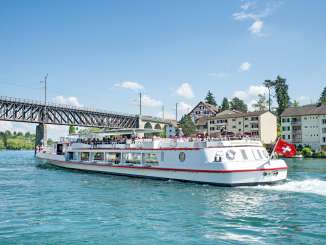 The regular boat service passes under a railroad bridge.