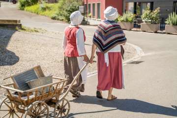 Wöschwiiber management Wilchingen Two Wöschwiiber walk through the village with a wooden cart. They wear a white hood.