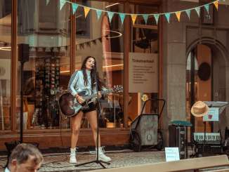 First Friday concert in front of VC A woman with a guitar gives a concert in the arbor in front of the Visitor Centre in the town of Schaffhausen.