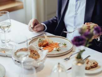 Gurmet Festival Schaffhausen An appetizer of salmon, a glass of white wine and bread are served on a white table.