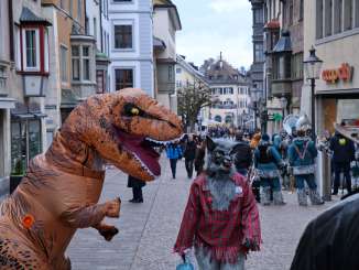 Fasnacht Old Town Schaffhausen At the carnival. A person in a dinosaur and wolf costume stands next to each other.