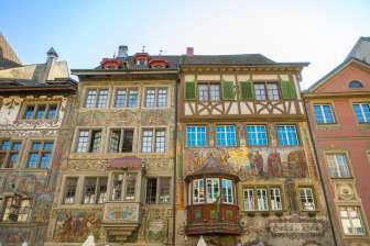 Four houses with old painted facades. Two oriel windows can also oriel windows , which protrude from the building.