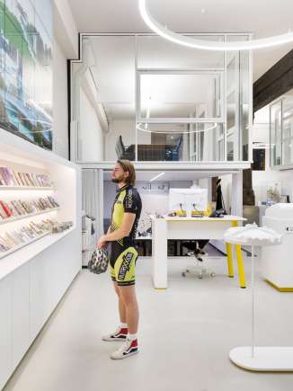 A cyclist stands in front of a brochure display and looks at brochures.