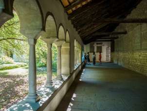 Five people are standing in the Schaffhausen cloister. A guide tells the group something.