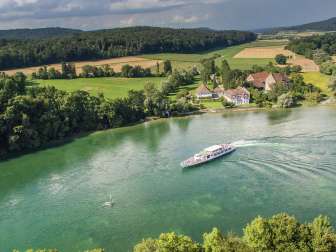 The view from above is of a shimmering green Rhine. The regular boat service operates on the Rhine.