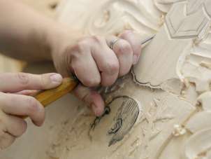 A tool is used to make a picture from a wooden panel.