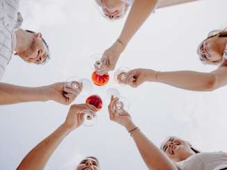 Räbhüüslifest Hallau Five friends hold wine glasses in the air and clink glasses.