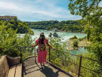 Tourist at the Rhine Falls A tourist wears a summer dress and stands at a viewpoint looking out over the Rhine Falls.
