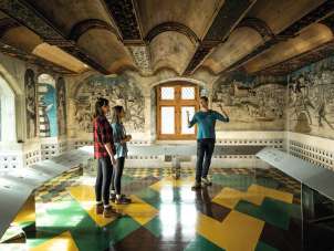 A group of three people stand in a room in the St. Georgen Monastery Museum.