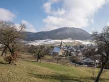 You look down from a slight rise onto a Klines village. A few places are still covered in snow.