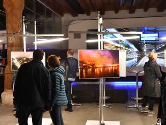 A photo exhibition with various visitors studying the pictures.