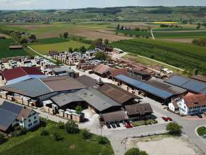 View of a sawmill from above. It is surrounded by meadows and fields.